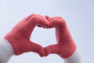 Kız ile kalp yapma kar eldiven eller. Sevgi işareti.