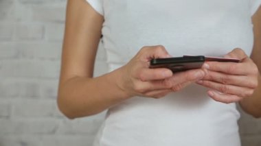 Holding kredi kartı elleri ve bir akıllı telefon numarasını girer. Ağır çekim