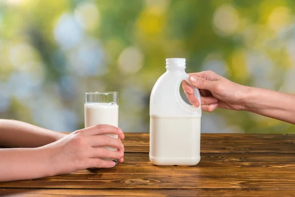 Moeder handen met fles van melk en childs holding van glas — Stockfoto