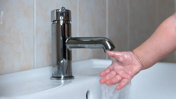 Baby wäscht seine Hand unter fließendem Wasser im Badezimmer. — Stockfoto