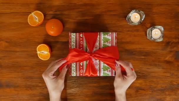 Дівчина відкриває подарункову коробку на день народження з червоною стрічкою, вид зверху — стокове відео