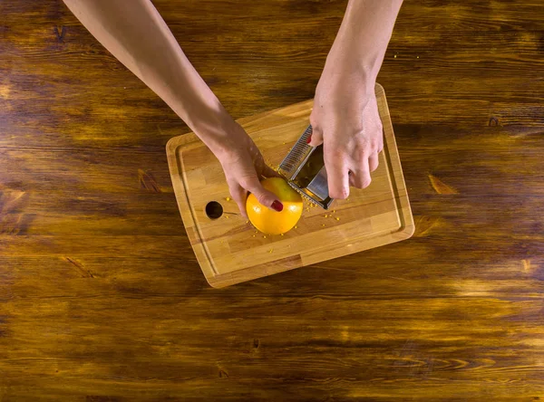 Woman prepare orange peel for dessert dish — Stock Photo, Image