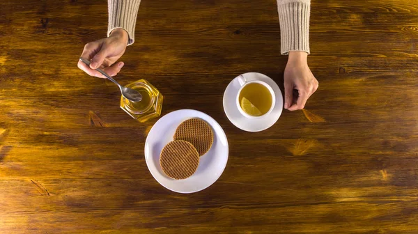 Γυναίκα πίνοντας τσάι με λεμόνι, μέλι και βάφλες — Φωτογραφία Αρχείου
