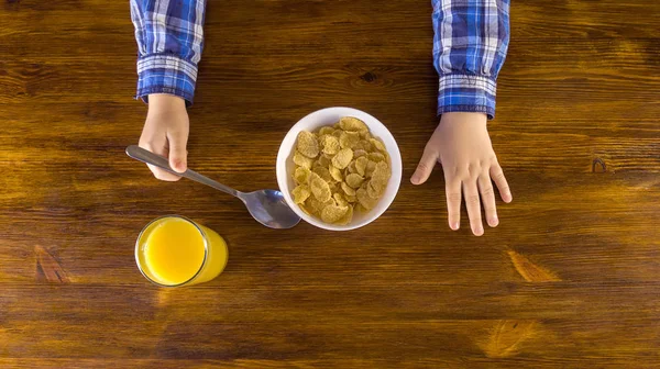 Milý chlapeček, Kukuřičné vločky na snídaně a pití pomerančová šťáva Stock Fotografie