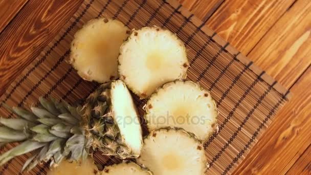 Ananas mit Scheiben auf Holztisch — Stockvideo