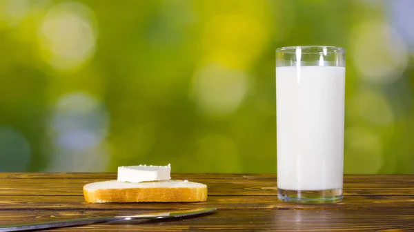 Glas melk en brood met fetakaas op de tafel in de tuin — Stockfoto