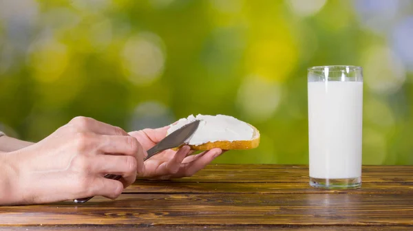 Beyaz peynir ekmek üzerine koyarak kadın. Bahçede kahvaltı — Stok fotoğraf