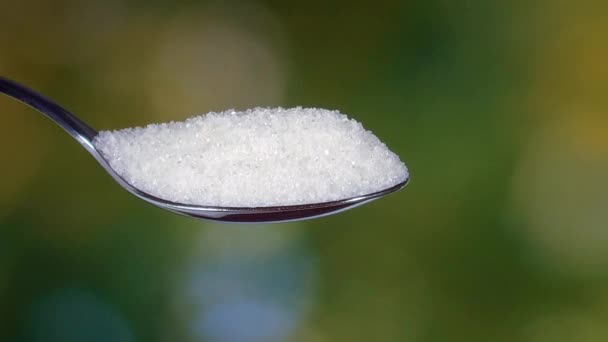 Sugar pouring from a spoon outdoors — Stock Video