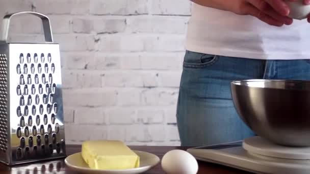 女人裂纹鸡蛋放入碗里，站到磅秤。烹饪的概念 — 图库视频影像