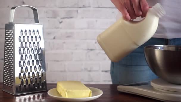 Mujer preparando masa y vertiendo leche en un tazón, cámara lenta — Vídeos de Stock