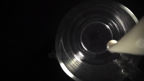 Verser le lait dans la tasse en verre sur fond noir — Video