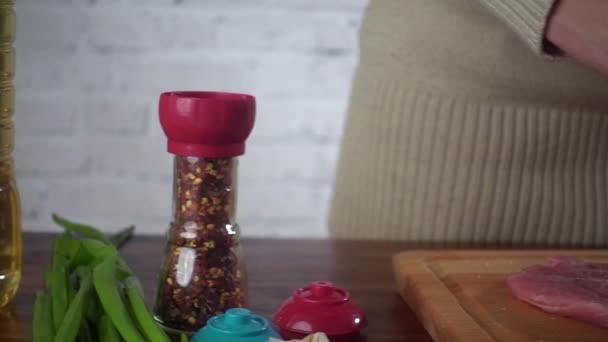 Kvinna förbereder biff och salt det med kvarn — Stockvideo