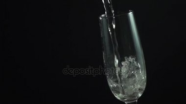Siyah arka plan üzerine bir cam içine dökme şampanya yavaş hareketli hd video