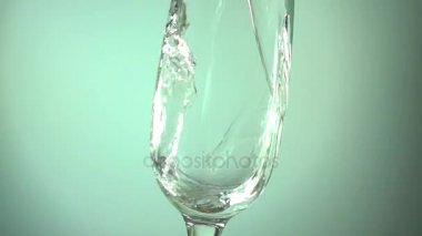 Açık mavi renkli üzerinde bir cam içine dökme şampanya yavaş hareketli hd video