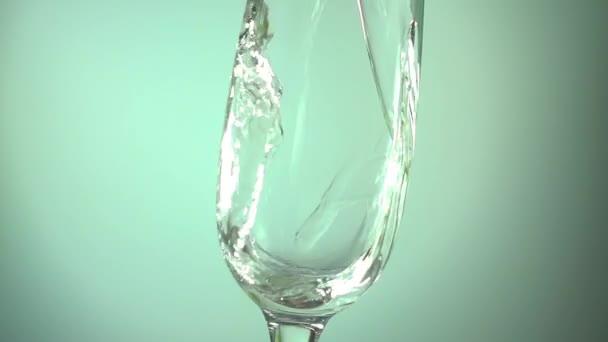 Шампанское наливая в стакан на светло-голубом фоне, замедленной съемки видео — стоковое видео