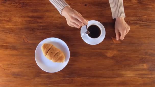 Mulher bebendo café preto com croissant no café da manhã — Vídeo de Stock
