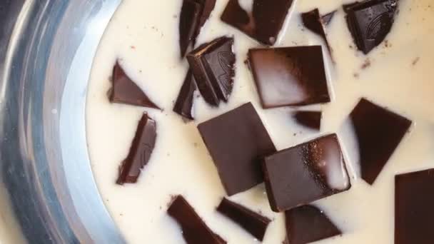 Таяние кусочков шоколада с молоком в миске, вид сверху, время истечения видео — стоковое видео