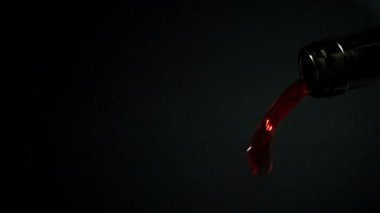 Siyah arka plan, yakın çekim ağır çekim hd video üzerine yeşil şişe kırmızı şarap dökme