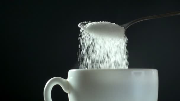 White sugar pouring from spoon to white mug, close-up slow motion hd video — Stock Video