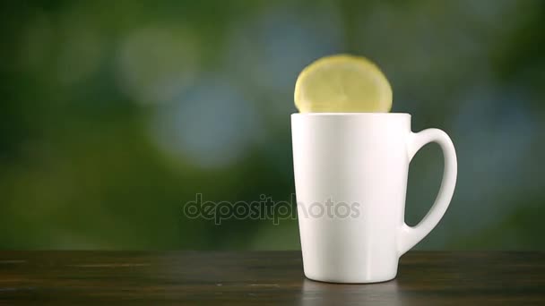 Piece of lemon drop in cup of hot water, super slow motion hd video — Stock Video
