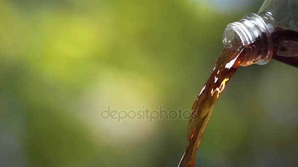 Vylévající cola z pet láhve na přírodní zelené poza, super zpomaleně