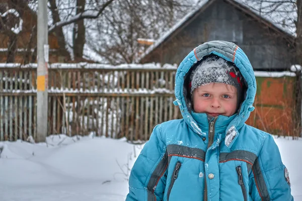 Söt rolig pojke och snö på det — Stockfoto