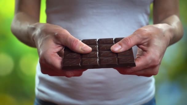 Mujer rompe una barra de chocolate, primer plano super cámara lenta de vídeo — Vídeo de stock