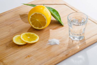 Tekila ve bir tepsi üzerinde beyaz izole limon tuzu