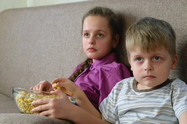 Hermano con hermana viendo dibujos animados con palomitas de maíz — Foto de Stock