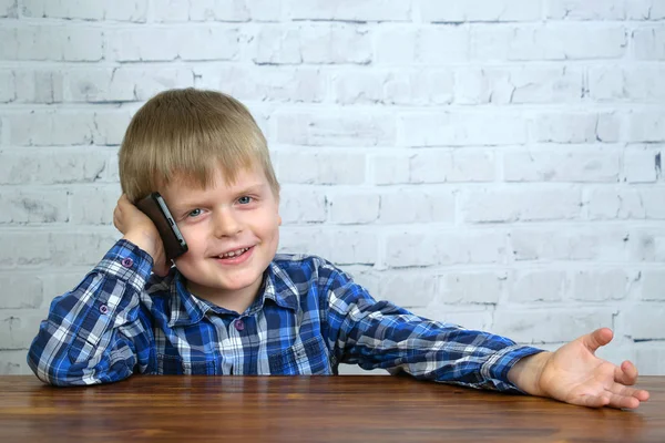 Cute little boy speaking by large smartphone — Stock Photo, Image