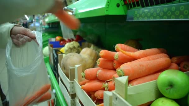 Mujer toma una zanahoria de la estantería en el mercado, hd video — Vídeo de stock