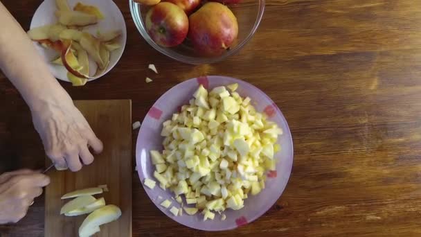 Mujer de edad avanzada está cortando la manzana madura fresca para mermelada, vista superior hd video — Vídeos de Stock