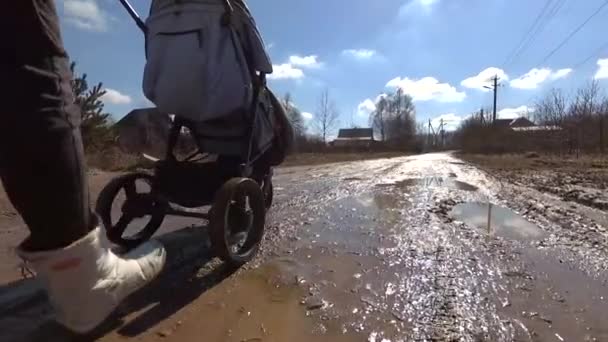 Fille marche avec une poussette sur une route de campagne de terre, vidéo HD — Video