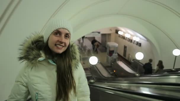 Lovaglás mozgólépcsőn a metróban, boldog, szép nő portréja — Stock videók