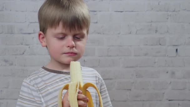 Lindo niño con plátano fresco maduro, vídeo hd — Vídeo de stock