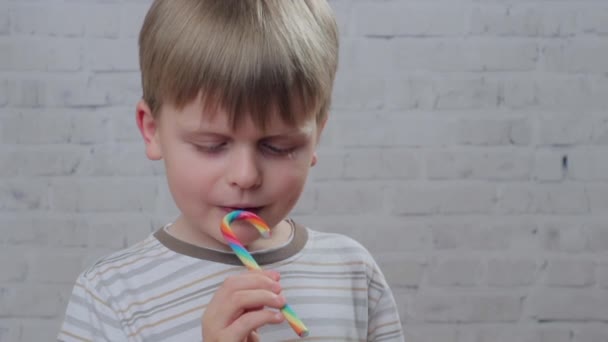 Söt liten pojke äter lollipop och ler, Slowmotion hd-video — Stockvideo