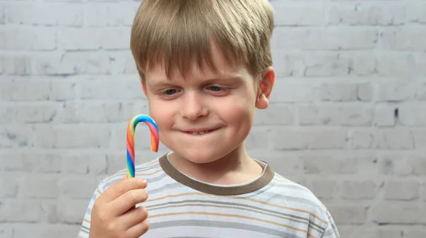 Cute little boy with colorful candy in hands — Stock Photo, Image