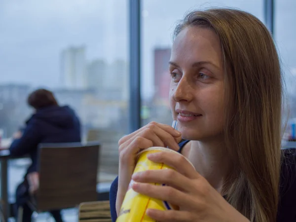 Женщина в кафе пьет соломинку — стоковое фото