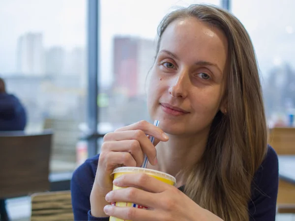 Женщина в кафе пьет соломинку — стоковое фото