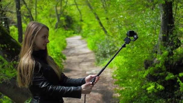 Mujer haciendo selfie en la acción cam con selfie palo en el parque, hd video — Vídeos de Stock