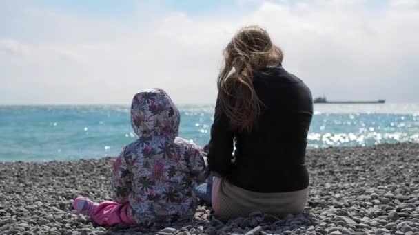 ピンクでかわいい女の子と母親は春の時間でビーチで遊んでください。 — ストック動画
