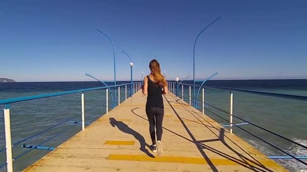 Chica corriendo en el muelle al atardecer, cámara lenta hd video — Vídeos de Stock