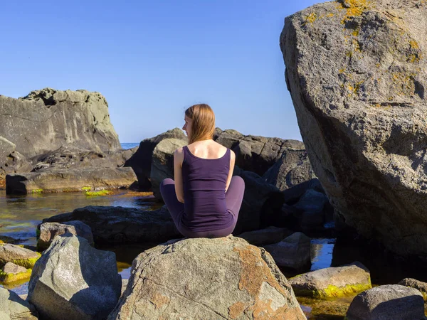 Ragazza pratica yoga vicino al mare, sulla roccia, rallentatore hd video — Foto Stock