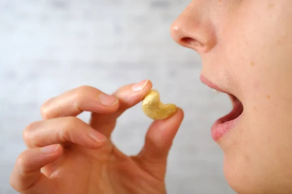 Close-up of woman eating cashew nuts — Stock Photo, Image