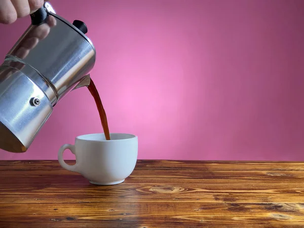 Рука наливает кофе из горшка Мока в кружку — стоковое фото