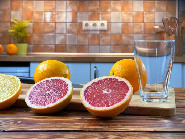 Empty glass with slices of grapefruits on wooden table — Stock Photo, Image