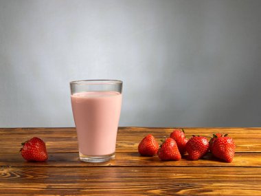 Çilekli yoğurt ya da ahşap masadaki camda smoothie.