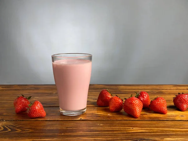 Erdbeerjoghurt oder Smoothie im Glas auf Holztisch — Stockfoto