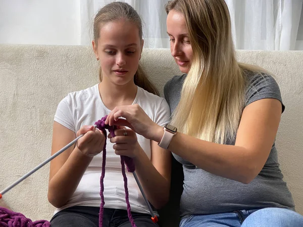 Una madre enseñando a su hija a tejer . — Foto de Stock