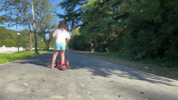 Молодая женщина со скутером в парке — стоковое видео